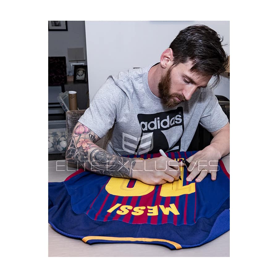 Lionel Messi signing a shirt